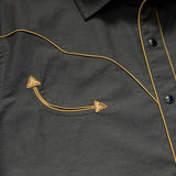 Close-up of the Broncbuster Snapshirt by Howler Brothers, featuring yellow piping, pearl snap buttons, and a pocket with decorative stitching and two triangular accents.