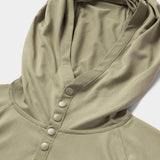 Close-up of the Duck Camp Bug Screen First Layer Hoodie in light olive green, featuring four snap buttons and a small embroidered logo on textured fabric—ideal for lightweight sun protection.