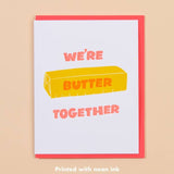 The Butter Together Card by And Here We Are features the message "WE'RE BUTTER TOGETHER" with a cute butter stick illustration, letterpress printed in neon ink on a white and pink love card.
