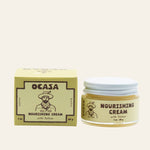 A jar of Nourishing Unscented Tallow Cream | OCASA next to its square box, both featuring a logo of a man in a wide-brimmed hat.