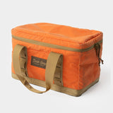 The Duck Camp Canvas Ammo Tote- Blaze is a rectangular orange canvas bag with tan handles and trim, zippered top, and front "Duck Camp" label—ideal as a durable tote for your outdoor essentials.