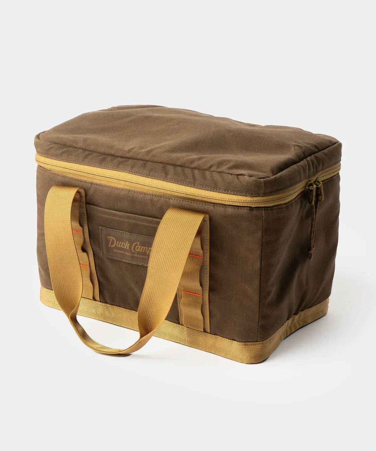 The Duck Camp Canvas Ammo Tote, a brown rectangular soft cooler bag made from waxed canvas with yellow handles and a zippered lid, is shown on a plain white background.
