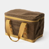 The Duck Camp Canvas Ammo Tote, a brown rectangular soft cooler bag made from waxed canvas with yellow handles and a zippered lid, is shown on a plain white background.