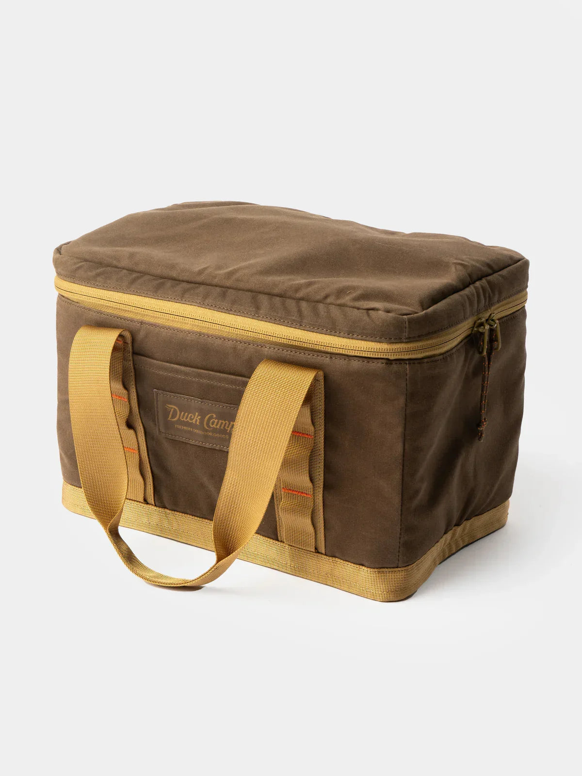 The Duck Camp Canvas Ammo Tote, a brown rectangular soft cooler bag made from waxed canvas with yellow handles and a zippered lid, is shown on a plain white background.
