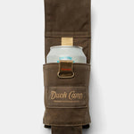 The Duck Camp Canvas Can Holster, a brown waxed canvas holder with a beige strap, is displayed holding a canned beverage against a plain white background.