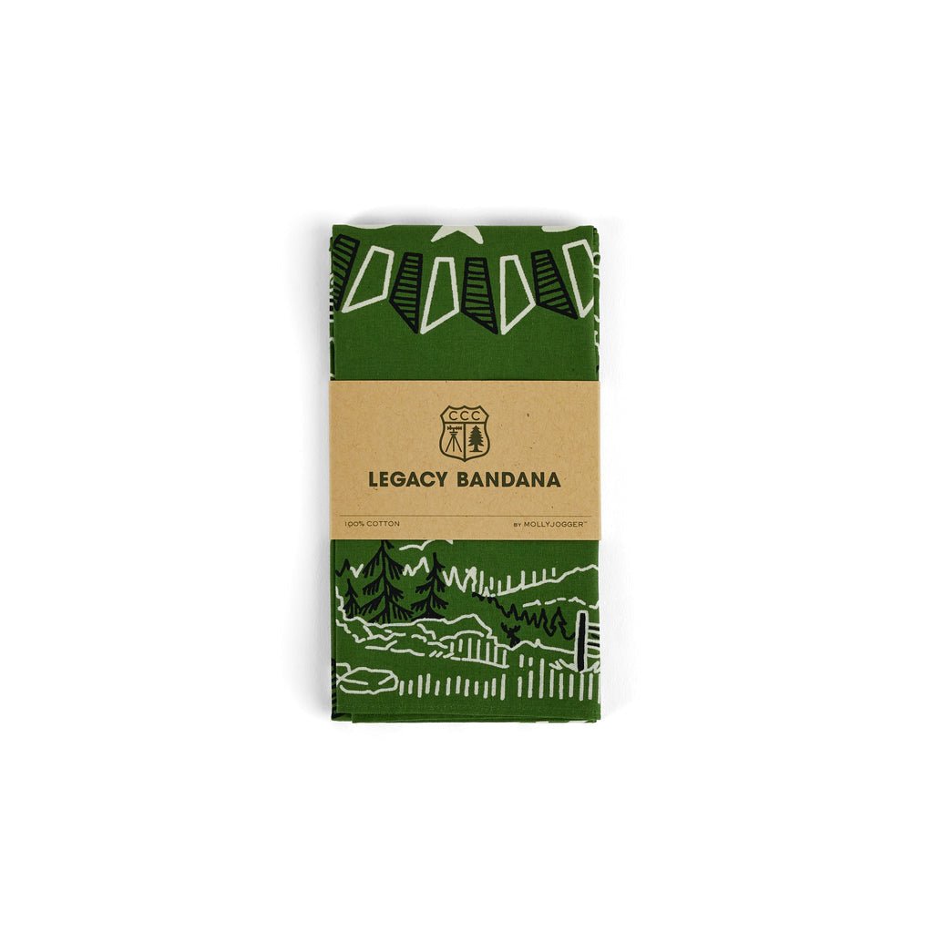 The CCC Legacy Bandana by Mollyjogger is a folded green 100% cotton bandana featuring white outdoor illustrations, wrapped in a brown label and inspired by the Civilian Conservation Corps.