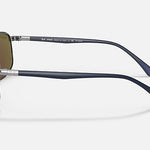 Side view of Ray-Ban 3671 Chromance rimless polarized sunglasses featuring purple-tinted lenses, a silver bridge and temples, and dark blue arms against a plain background.