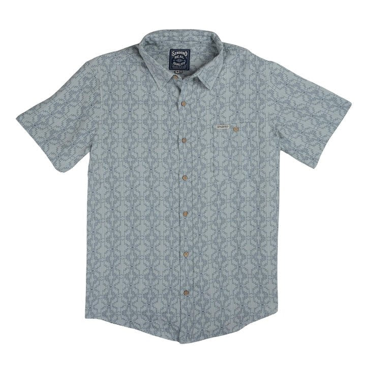 The City Slicker | Arizola Chevron from Sendero Provisions Co. is a light blue, short-sleeve, button-up shirt with a subtle geometric pattern, front chest pocket, and small label above the pocket.