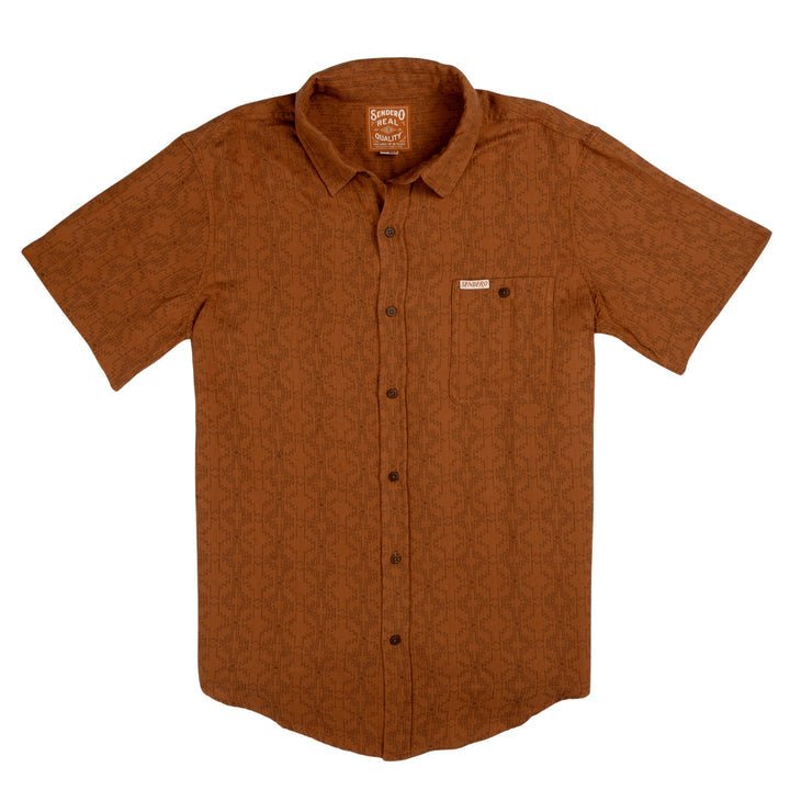 The City Slicker | Arizola Chevron by Sendero Provisions Co. is a short-sleeve, button-up shirt in burnt orange with a subtle chevron pattern, chest pocket, and collar—ideal for capturing cool desert vibes.