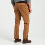 A person is seen from behind in Duck Head's Classic Fit Brushed Back Chino, paired with a checkered shirt and brown sneakers, standing against a plain background.