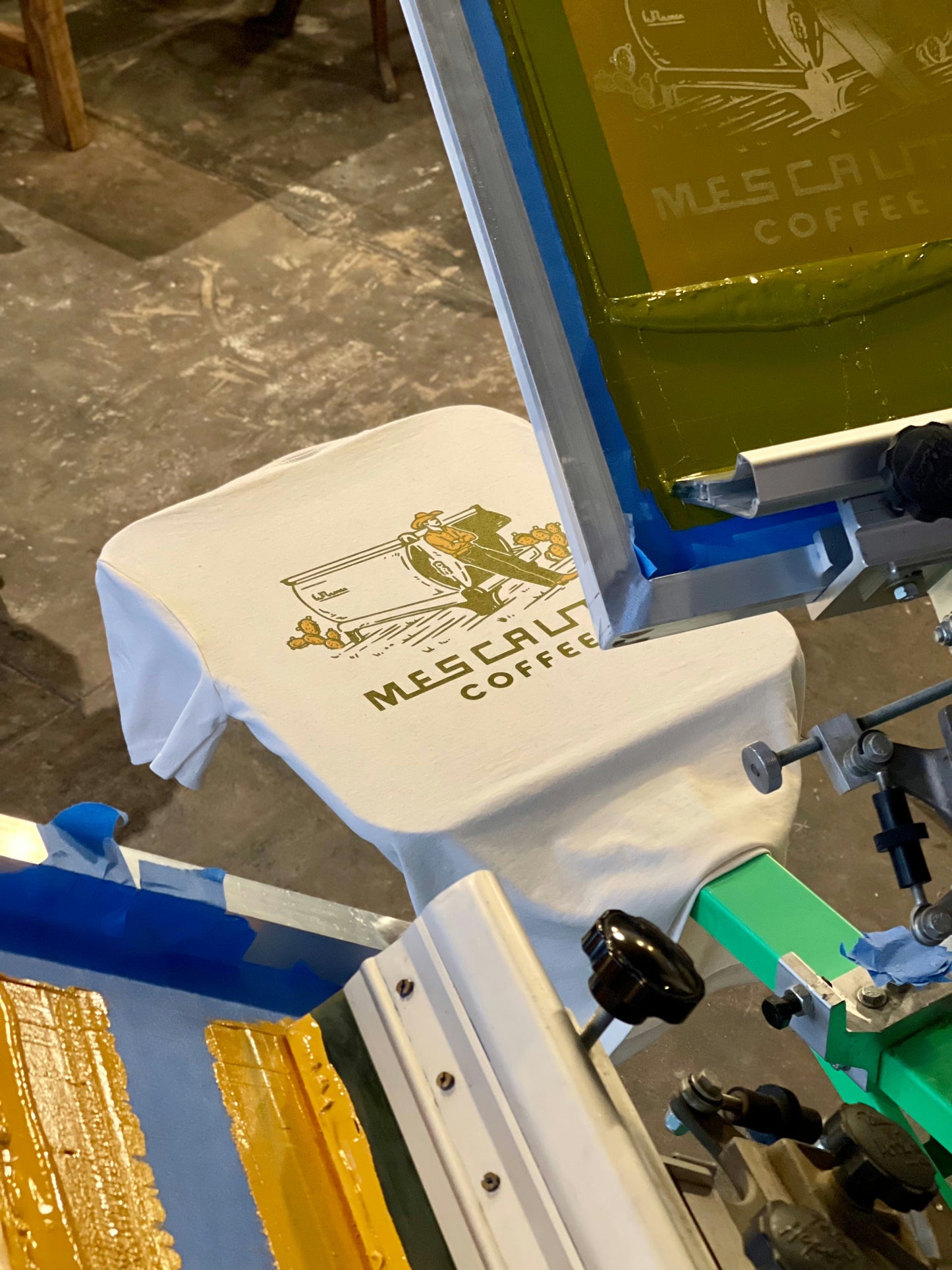 A white T-shirt is screen printed with the “Coffee Cowboy | Mescalito Coffee” logo by Mescalito Coffee, capturing cowboy spirit—a bold shirt for strong coffee lovers and fans of rugged style.