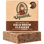 Dr. Squatch Bar Soap in Cold Brew Cleanse features visible coffee grounds, a "Heavy Grit" label, and a cartoon Sasquatch with a pipe—delivering robust cleansing power with real caffeine infusion.