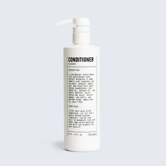 A white pump bottle labeled "Conditioner | Blu Atlas" features black text instructions and description, highlighting a lightweight formula with Argan Oil by Blu Atlas that moisturizes hair for smooth, healthy-looking results.