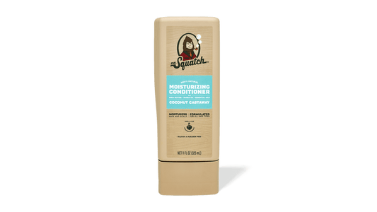 A beige bottle of Dr. Squatch Conditioner in the Coconut Castaway scent, featuring nourishing avocado oil, stands upright against a plain white background.