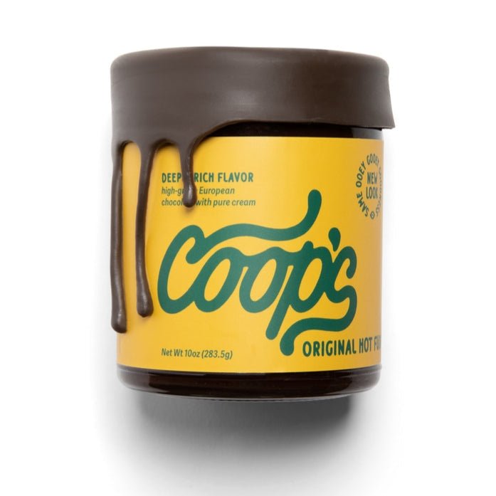 Coop’s | Original Hot Fudge features a jar with chocolate drips on the lid, a yellow label with green text, and offers rich, handmade chocolate sauce inspired by European traditions.