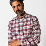 Man with dark hair and beard wears the Duck Head Cotton Flannel Sport Shirt—red, white, and blue plaid—standing against a plain white background.