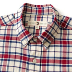 The Cotton Flannel Sport Shirt by Duck Head features a red, blue, and white plaid pattern, button-down front, collar, and a branded label inside the neck.