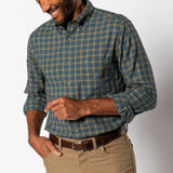 A man wears a Duck Head Cotton Wool Sport Shirt in Orion Blue and yellow, tucked into tan pants with a brown belt, standing against a plain white background.