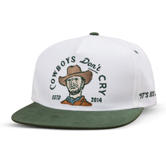 The Sendero Provisions Co. Cowboys Don't Cry Hat is a white and green baseball cap with an embroidered cowboy face, "COWBOYS Don't CRY," "ESTD 2014" on the front, and "IT'S JUST" on the side.
