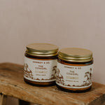 Two jars of Cowboy & Co.'s COWGIRL Vanilla Infused Tallow sit on a rustic wooden stool against a neutral background—ideal for sensitive skin.