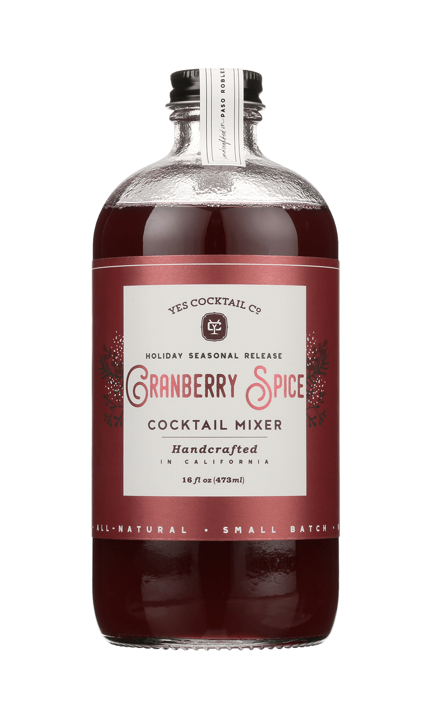 A 16 fl oz (473 ml) glass bottle of red liquid labeled "Cranberry Spice" by Yes Cocktail Co., featuring holiday cocktail mixer seasonal release branding.