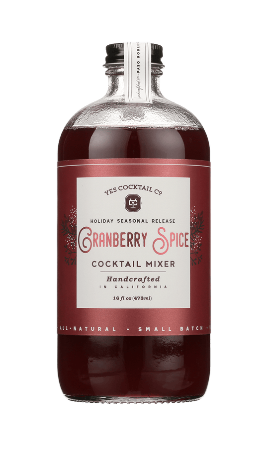 A 16 fl oz glass bottle of Cranberry Spice by Yes Cocktail Co., a handcrafted holiday cocktail mixer from California infused with mulling spices.