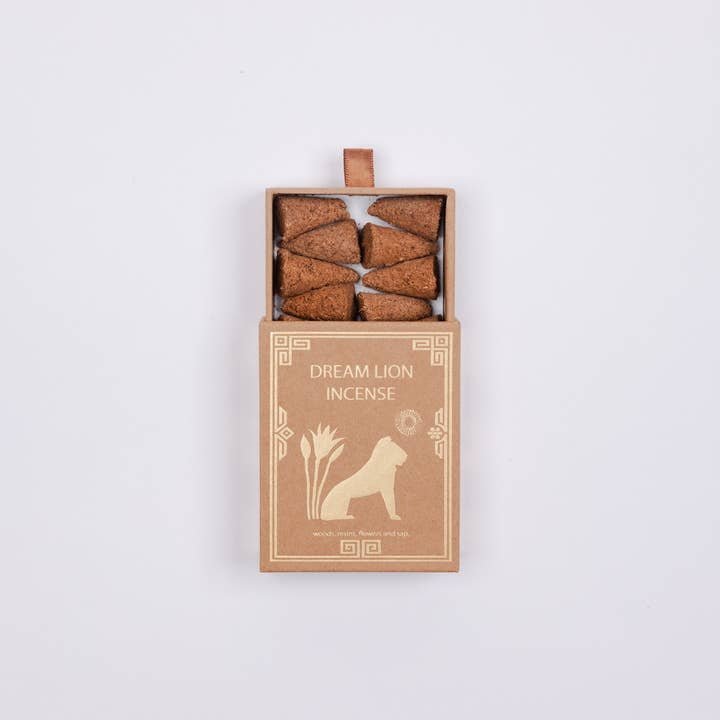 An open box labeled "Dream Lion Incense" reveals eight brown incense cones—Creative Imagination Sandalwood & Rose Petals Incense—blending soothing sandalwood and rose petals by Dream Lion Incense.