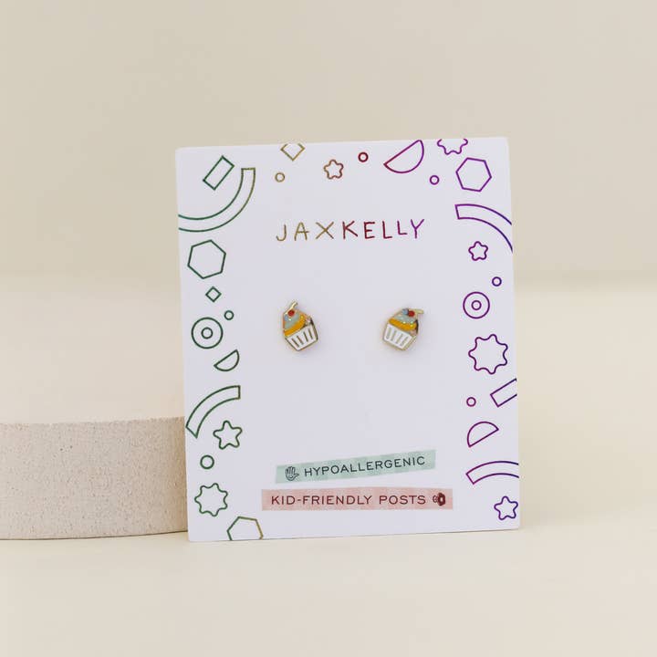 A pair of Cupcake Enamel Flat Back Kids Earrings by JaxKelly, displayed on a branded card labeled hypoallergenic and kid-friendly posts—perfect for sensitive ears.