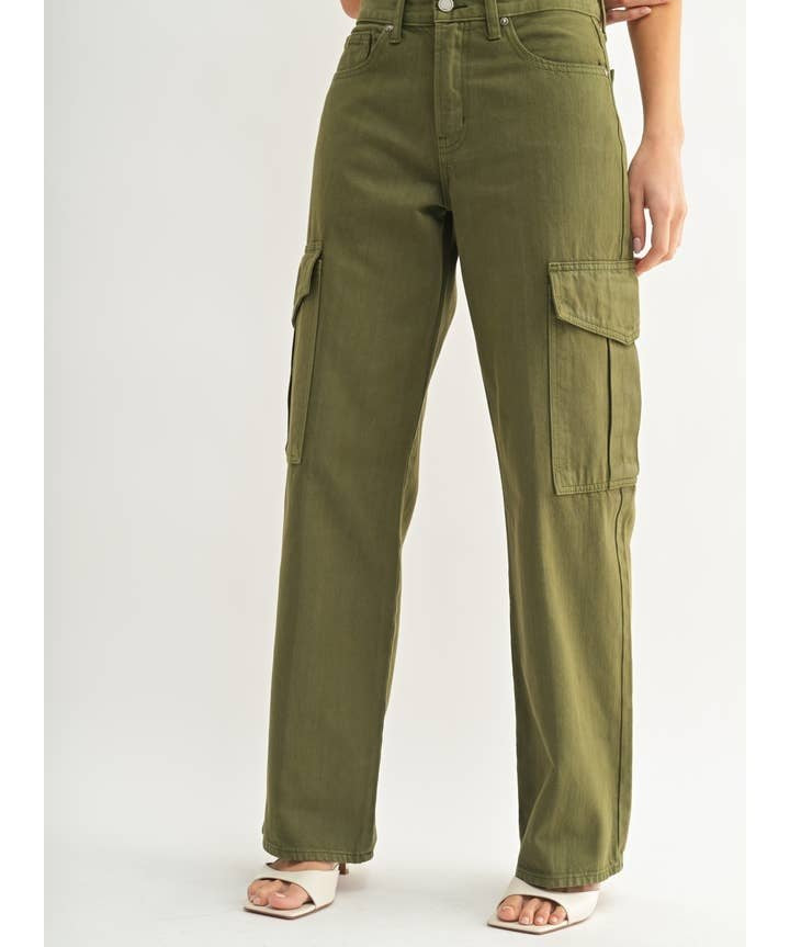 A person in JBD's Dark Olive Cargo high-waisted, wide-leg pants with side pockets, styled with open-toed heeled sandals and a cropped top.