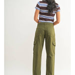 A person stands facing away, wearing a short-sleeve striped shirt and the JBD Dark Olive Cargo pants, which are high-rise, wide-leg with side pockets, against a plain white background.