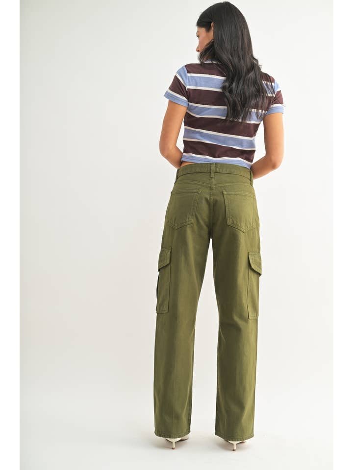 A woman faces away, wearing JBD Dark Olive Cargo pants and a short-sleeve brown and blue striped shirt against a plain light background.
