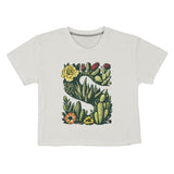 Ultra-soft and made from organic cotton, the Sendero Provisions Co. Desert Mark Boxy Tee features a white short sleeve design with an illustrated "S" formed by green succulents and colorful flowers.