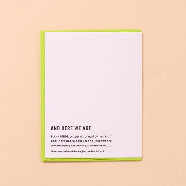 The Dilly Dally Pickle Birthday Card by And Here We Are is a white letterpress card with a green border, reading “AND HERE WE ARE.” It’s blank inside and hand printed by a woman-owned business.