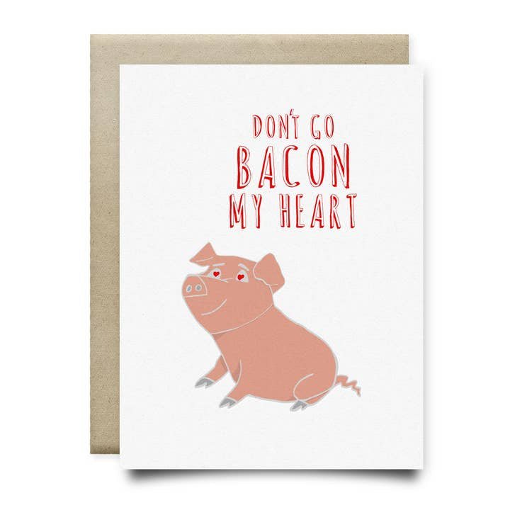 The “Don’t Go Bacon My Heart Card” by Anvil Cards is an A2 greeting card with a pig and red text, printed on linen paper. It’s blank inside and comes with a brown envelope.