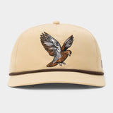 The Dove Hat by Duck Camp is a beige baseball cap with an embroidered bird in flight on the front and a brown trim above the brim—ideal for fans of dove poppers or bird snacks.