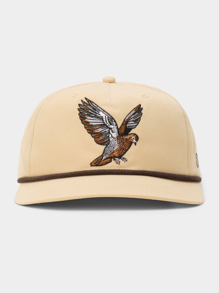 The Dove Hat by Duck Camp is a beige baseball cap with an embroidered bird in flight on the front and a brown trim above the brim—ideal for fans of dove poppers or bird snacks.