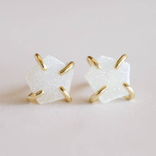 The Druzy Prong - White - Gold Earrings by JaxKelly feature glittery white druzy stones in pentagon shapes, set in gold prongs, shown against a neutral background.