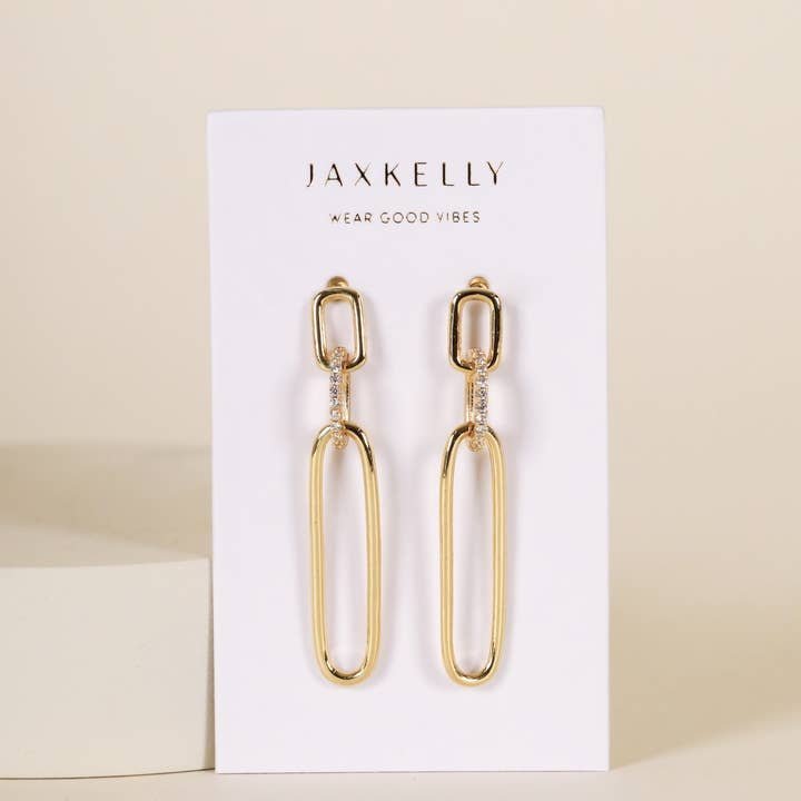 JaxKelly Pave Link Drop Earrings feature rectangular and oval gold links accented with white pavé stones. Displayed on a branded card reading "Wear Good Vibes." Hypoallergenic for comfortable wear; shown against a beige background.
