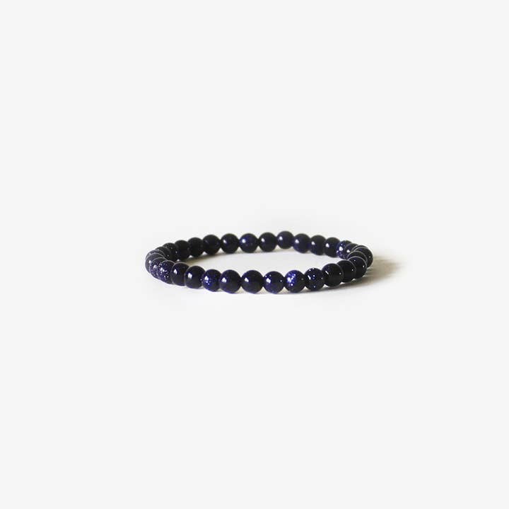 The Earth Bracelet - Blue Sandstone by BRANCO features polished, dark blue round gemstones arranged in a circle and is shown on a plain white background.