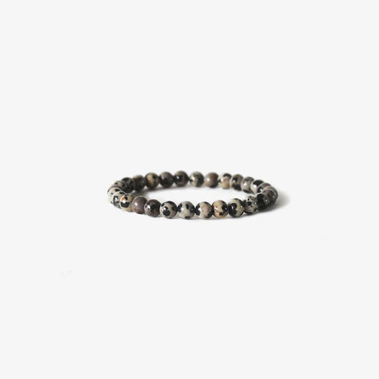 The Earth Bracelet - Dalmatian Stone by BRANCO features round, speckled gemstones arranged in a circle and is displayed on a plain white background.