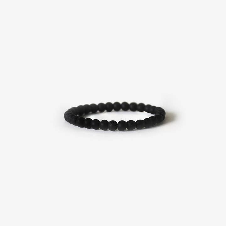 The Earth Bracelet - Matte Black Onyx by BRANCO is a simple beaded gemstone bracelet, displayed in a circular shape on a plain white background.