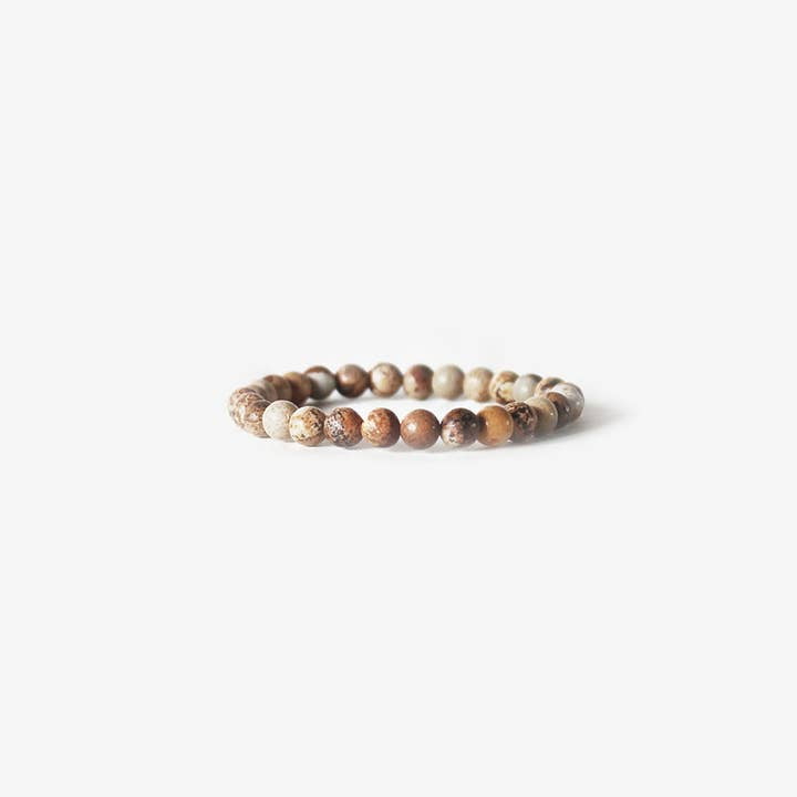 The Earth Bracelet - Picture Jasper by BRANCO features round, natural brown and beige picture jasper beads, arranged in a circular design and photographed on a white background.