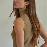 Tan Knit Turtleneck Sleeveless Pullover Top worn with blue jeans.