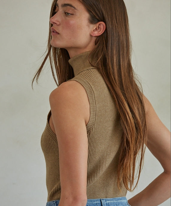 Tan Knit Turtleneck Sleeveless Pullover Top worn with blue jeans.