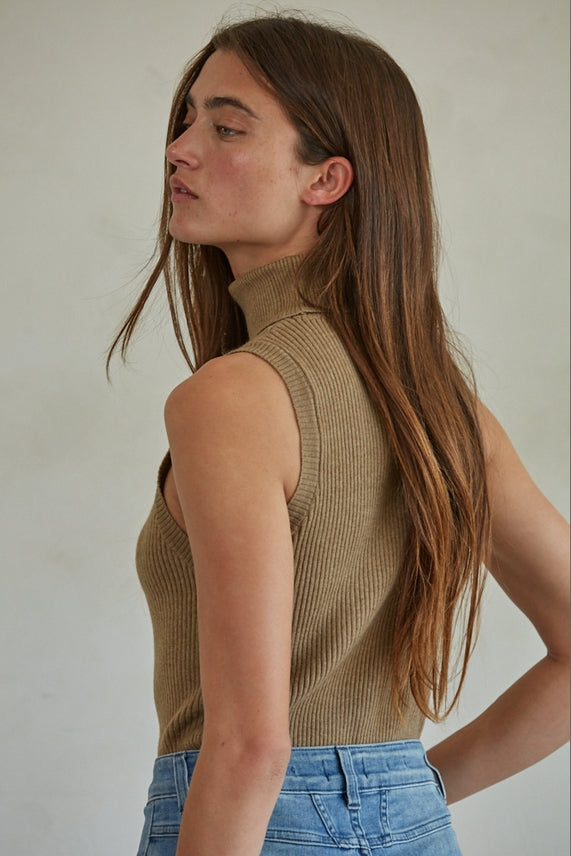 Tan Knit Turtleneck Sleeveless Pullover Top worn with blue jeans.