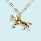 Wild Horses Necklace, a gold-tone necklace with a horse charm on a long-link cable chain.