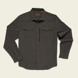 The Howler Brothers Emerger Tech Longsleeve is a dark gray, lightweight UPF shirt with long sleeves, button-up front, two chest pockets, a zippered pocket, and collar, shown laid flat on a light background.