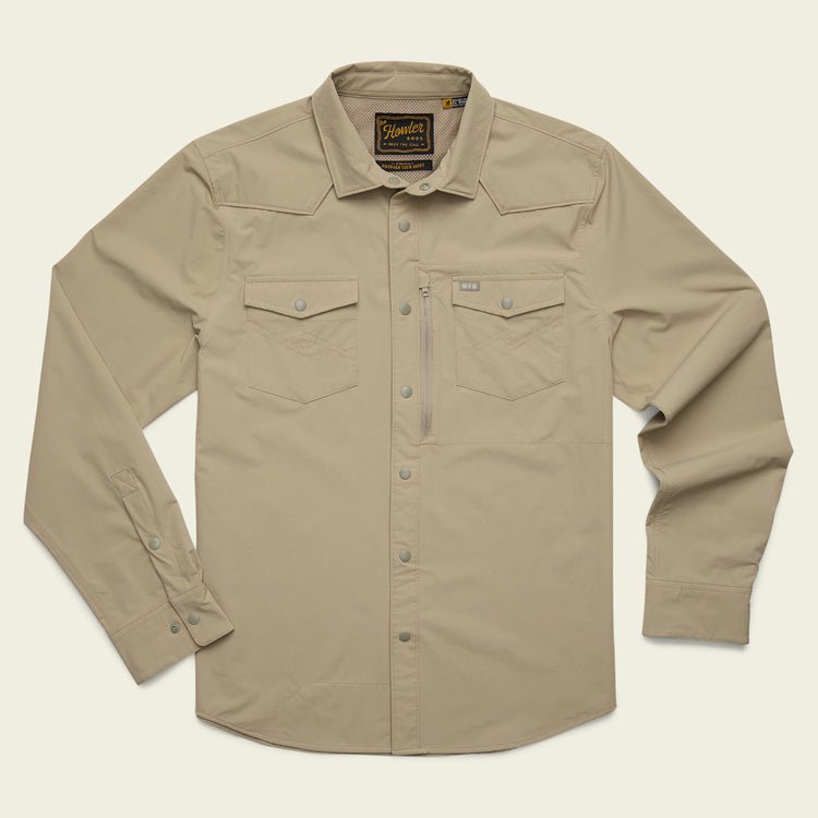 The Howler Brothers Emerger Tech Longsleeve is a light tan, lightweight shirt with UPF 35 protection, two chest pockets, snap buttons, and a collar—shown laid flat on a plain background.