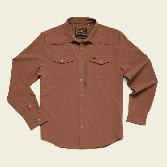 The Howler Brothers Emerger Tech Longsleeve, a brown shirt with UPF 35, features two chest pockets, a small zip pocket, and buttoned cuffs. It’s shown laid flat on a light background.