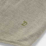 Close-up of the ultra-soft, light olive green Essential drirelease® Tank by Duck Camp, featuring a small embroidered "D" with a crown near the hem.